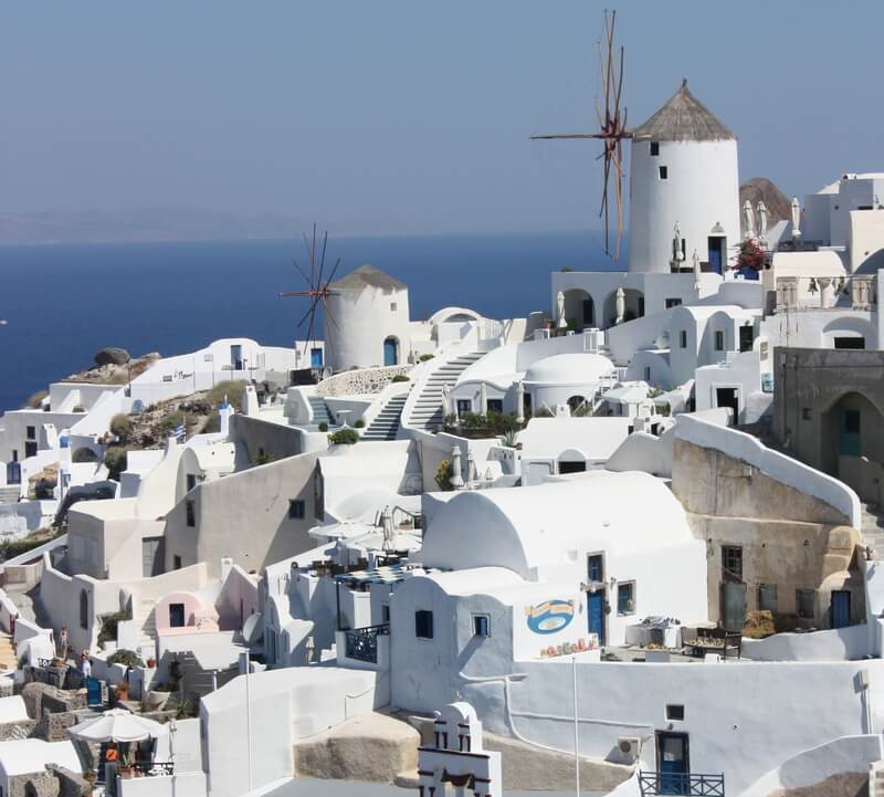 Windmills surrounded by the whitewashed cubic houses of Oia in Santorini